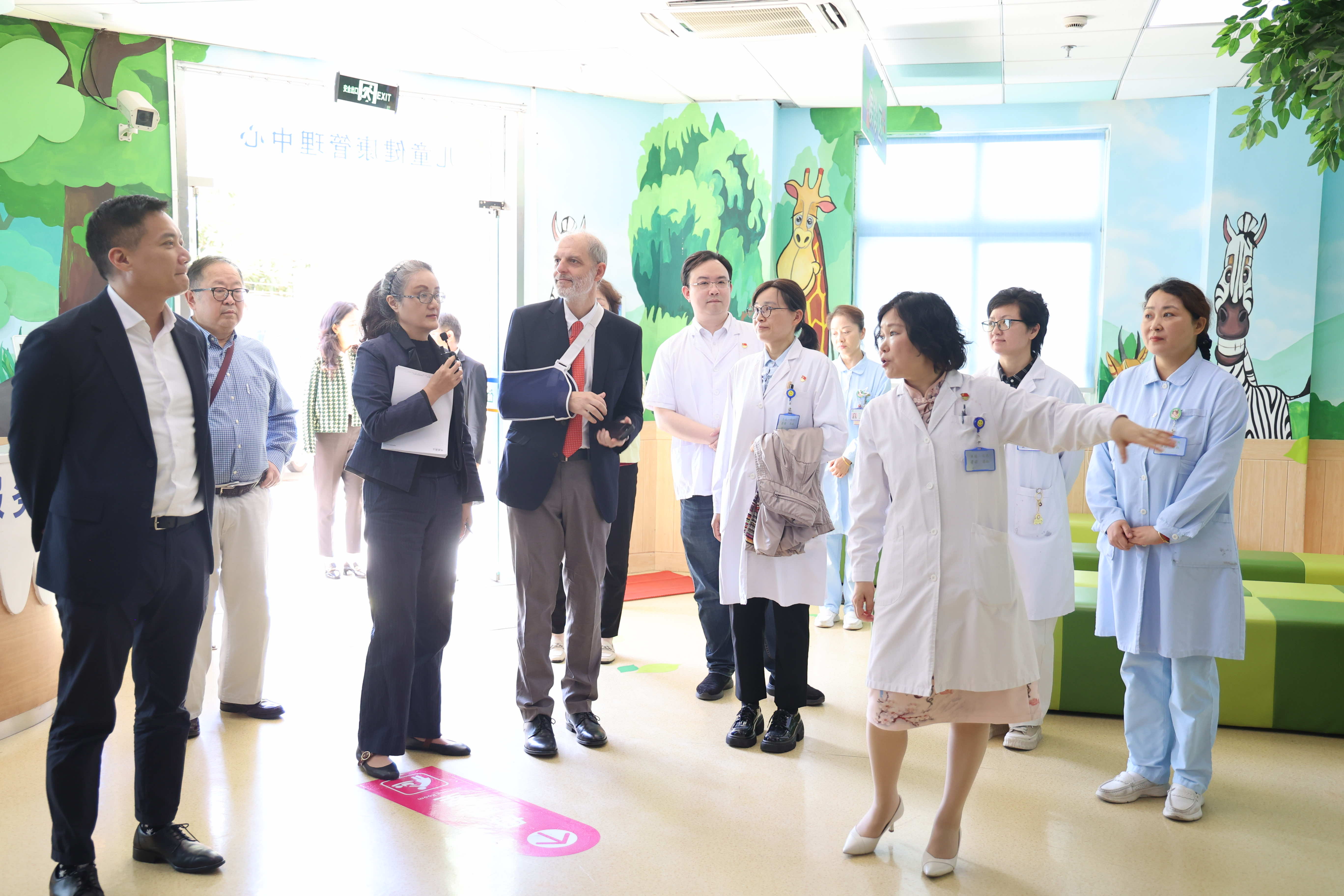 WONCA assessors tour the Gumei Community Health Service Centre with centre staff, walking through a paediatric waiting area in Minhang District, Shanghai